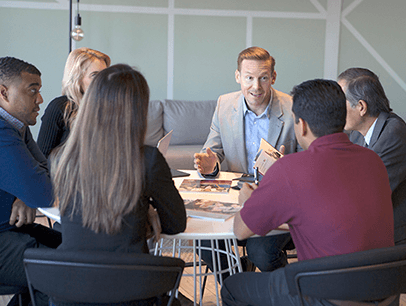 Men and women sitting around a conference table talking 