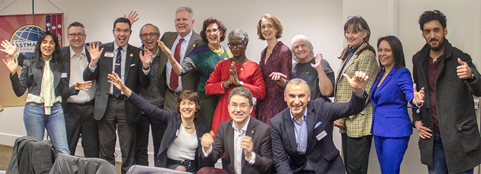 Large group of Toastmasters from London, England celebrating with hands in the air
