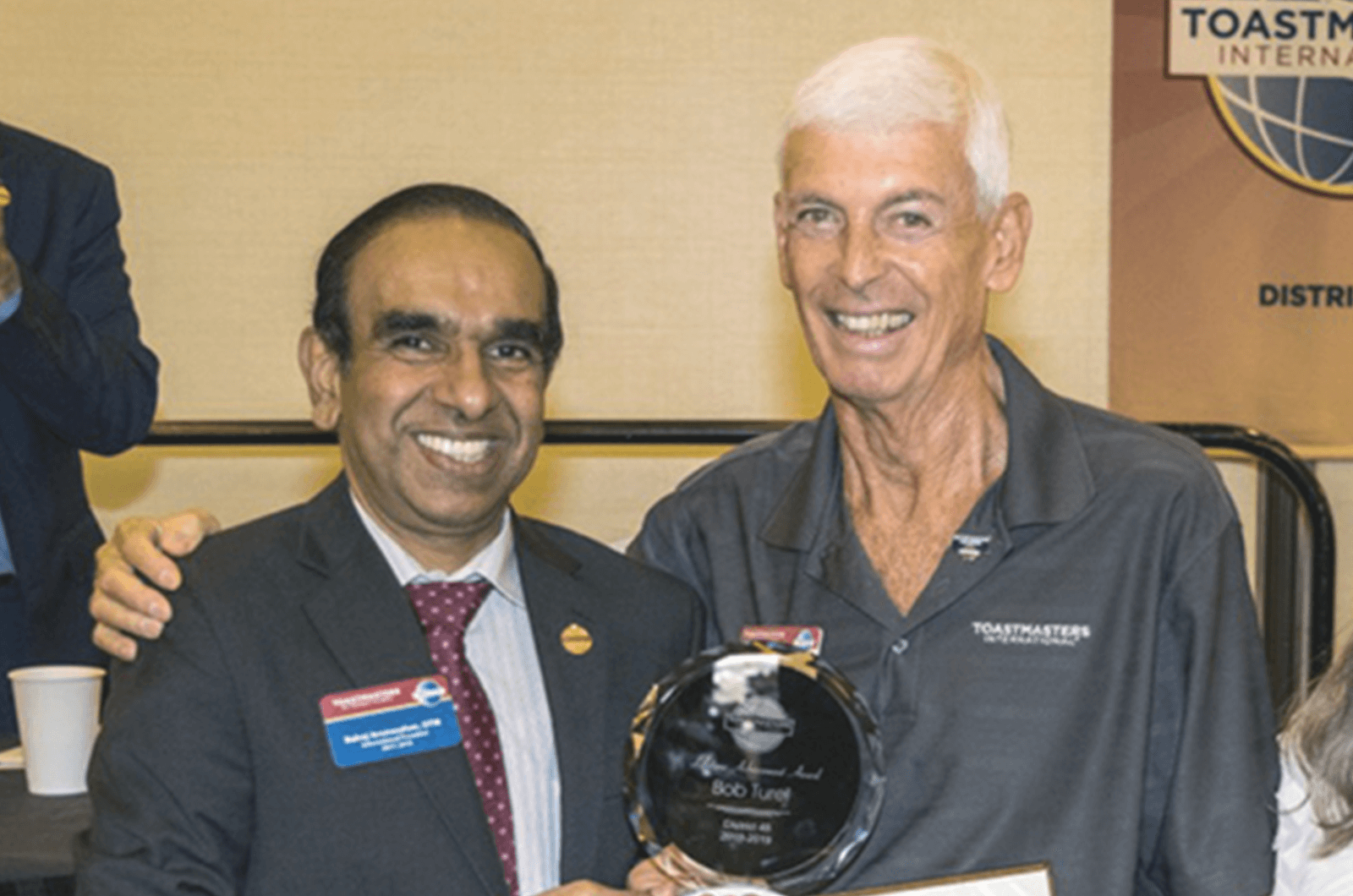 Toastmasters International President Deepak Menon awards member Bob Turel a certificate