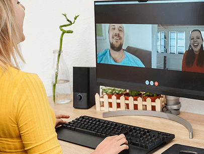 Woman in yellow shirt talking to man and woman on her computer