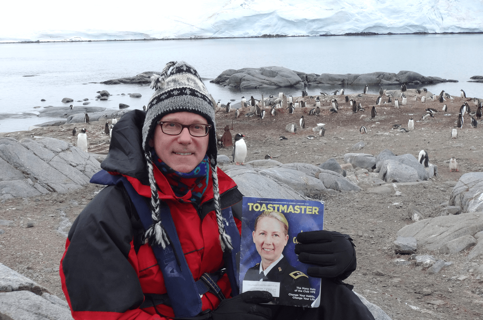 George Philip, DTM, of North Brunswick, New Jersey, U.S., poses with some penguins at Port Lockroy—a historic British base and the most southerly operational post office in the world—on Wiencke Island, off the coast of the Antarctic Peninsula.