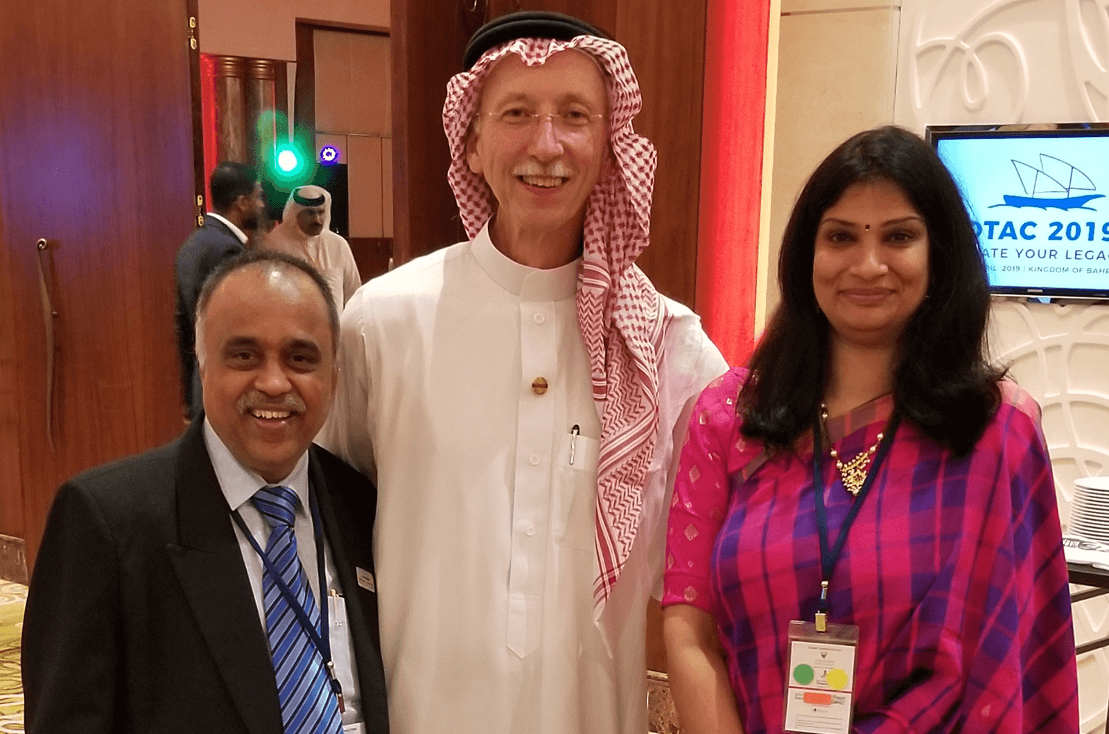 Peck, dressed in a traditional white robe and keffiyeh headpiece, poses with members at the 2019 District 20 Annual Conference. 