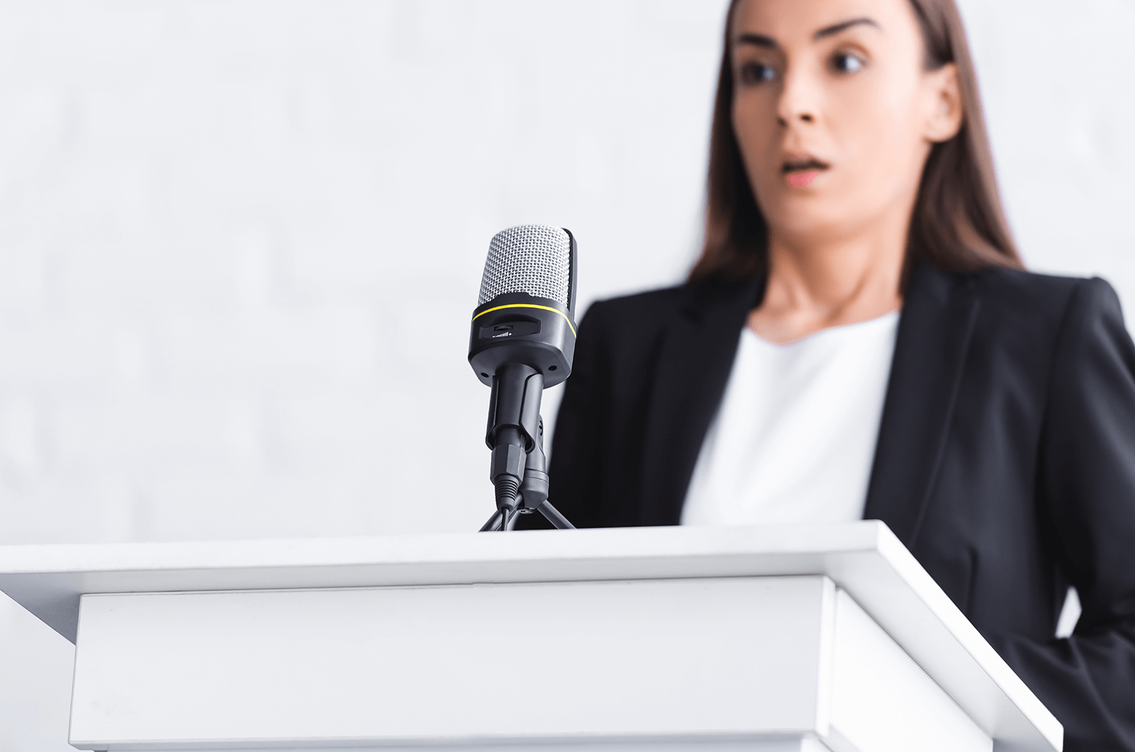 Woman standing at lectern looking scared