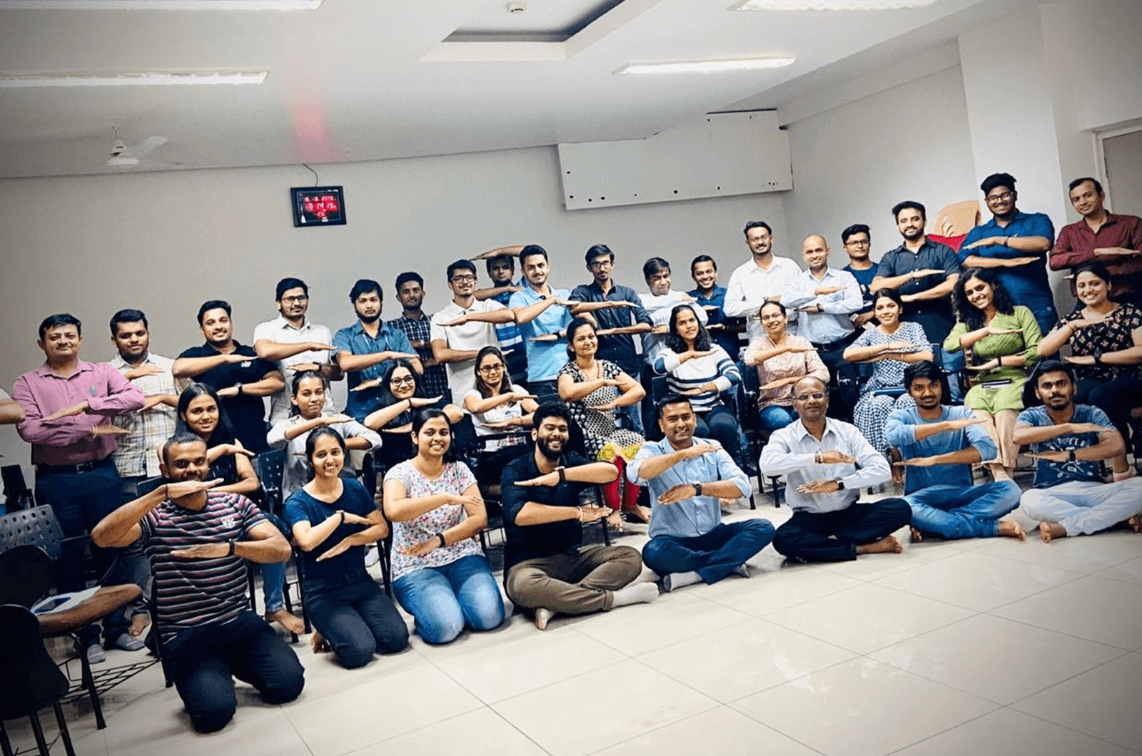 Group of Toastmasters in India posing with arms making equal signs