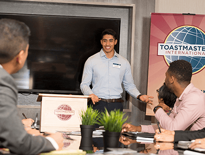 Man standing at lectern speaking at Toastmasters meeting