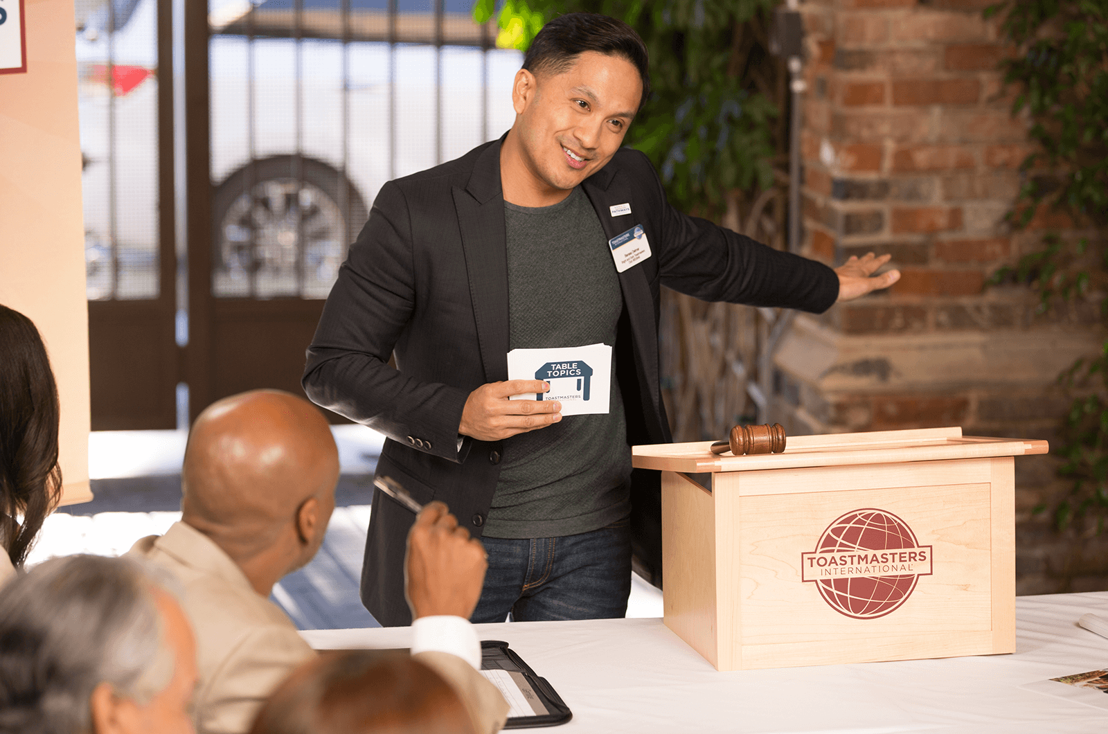 Man using hand gesture speaking at lectern