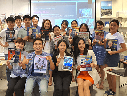 Group of people posing with Toastmaster magazines  
