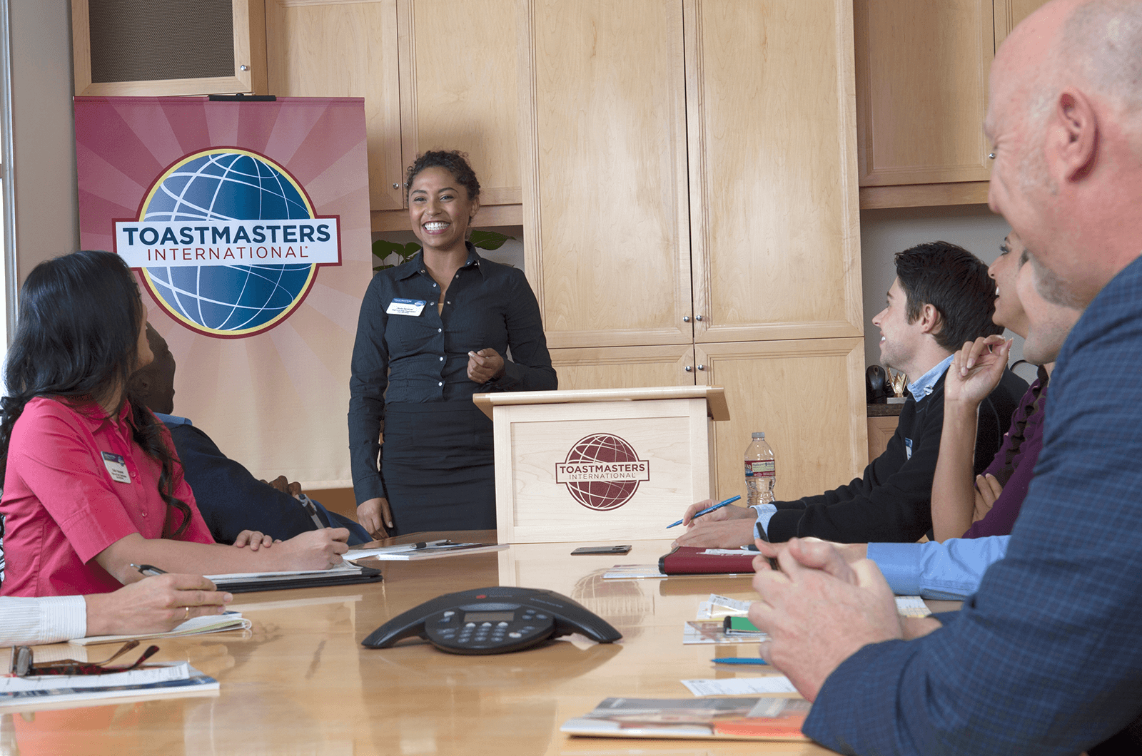 Woman standing at lectern speaking to group