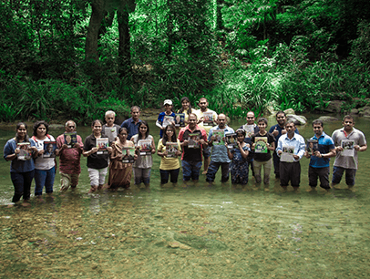 Group of people standing in a stream with Toastmaster magazines