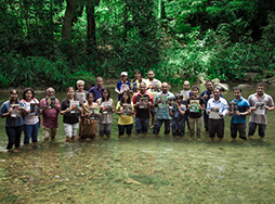 Group of people standing in a stream with Toastmaster magazines