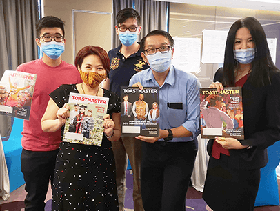 Group of people wearing medical masks holding magazines