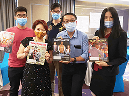Group of people wearing medical masks holding magazines