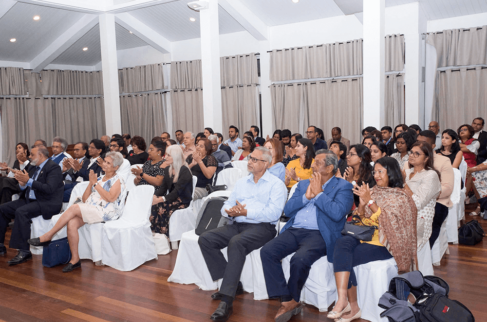 Attendees who attended the joint meeting in person listen closely to the speaker.