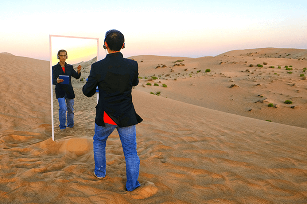 Man standing in front of mirror in desert