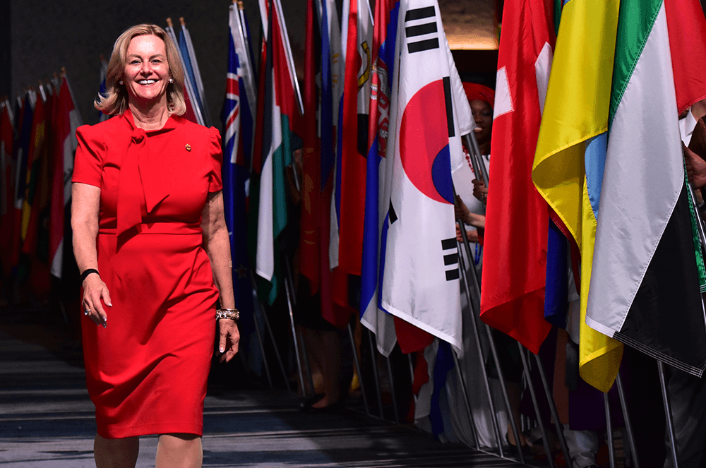 Page proudly walks past the display of flags at the 2018 International Convention in Chicago, Illinois.