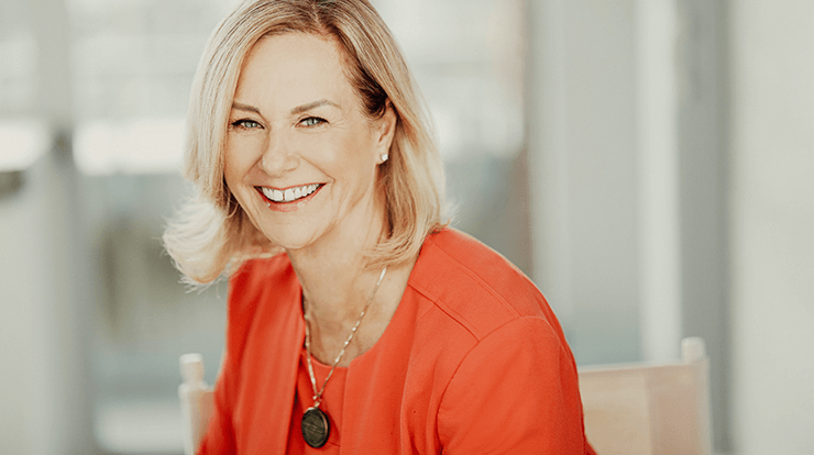 Margaret Page smiling in orange jacket