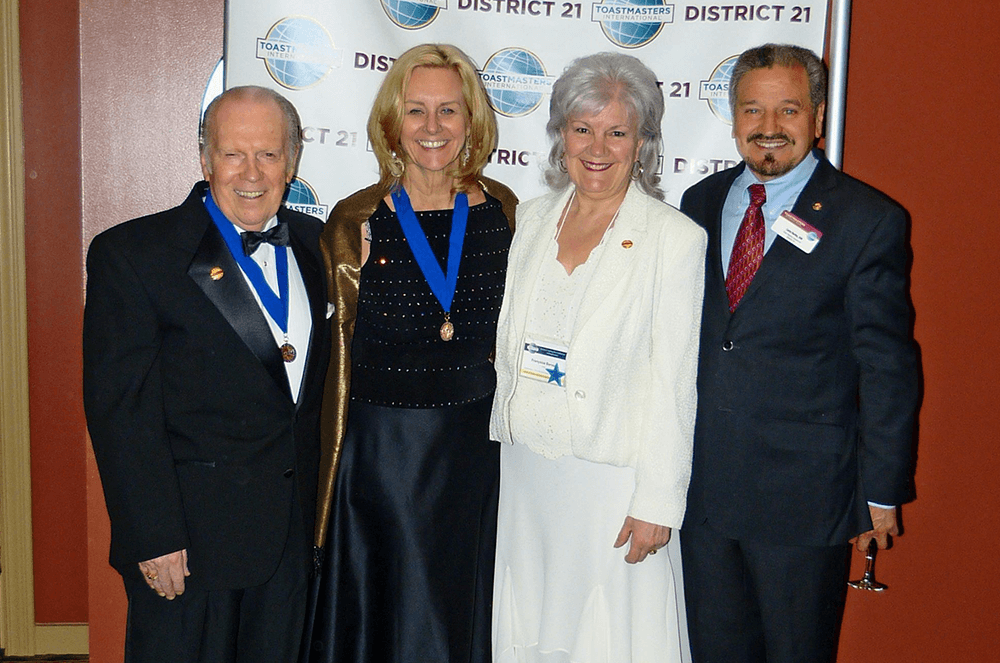 Page poses with Past District Governors from District 21 at a Toastmasters event.