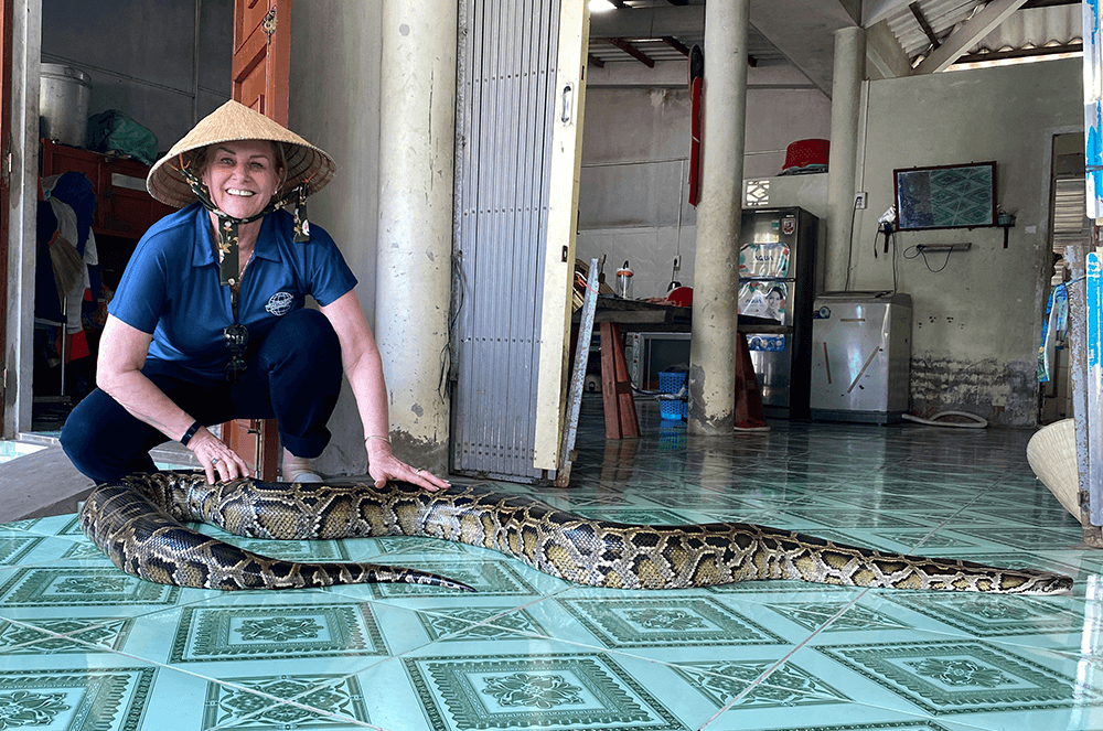 Margaret Page, DTM, greets a snake in Vietnam during Mid-year Training in 2019.