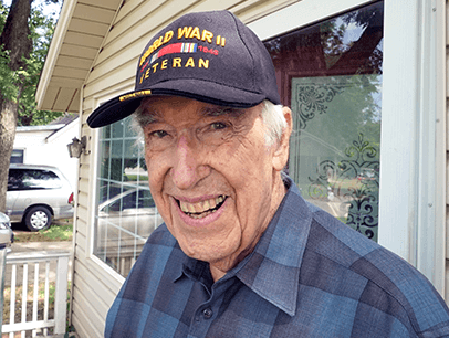 Man wearing veteran hat and smiling