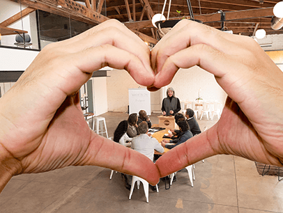 Hands forming heart shape around people