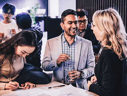 Man speaking to two women at networking event