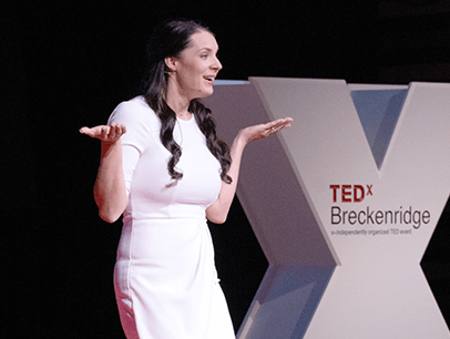 Woman speaking on TEDx stage 