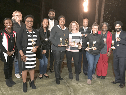 Group posing outdoors with awards