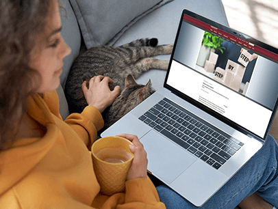 Woman reading on laptop while petting cat