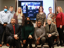 Group posing in front of screen