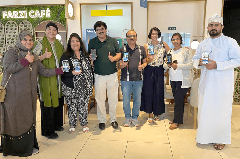 SAB Toastmasters Club members stay current with their digital Toastmaster magazines while gathering for an in-person club meeting in Muscat, Oman.